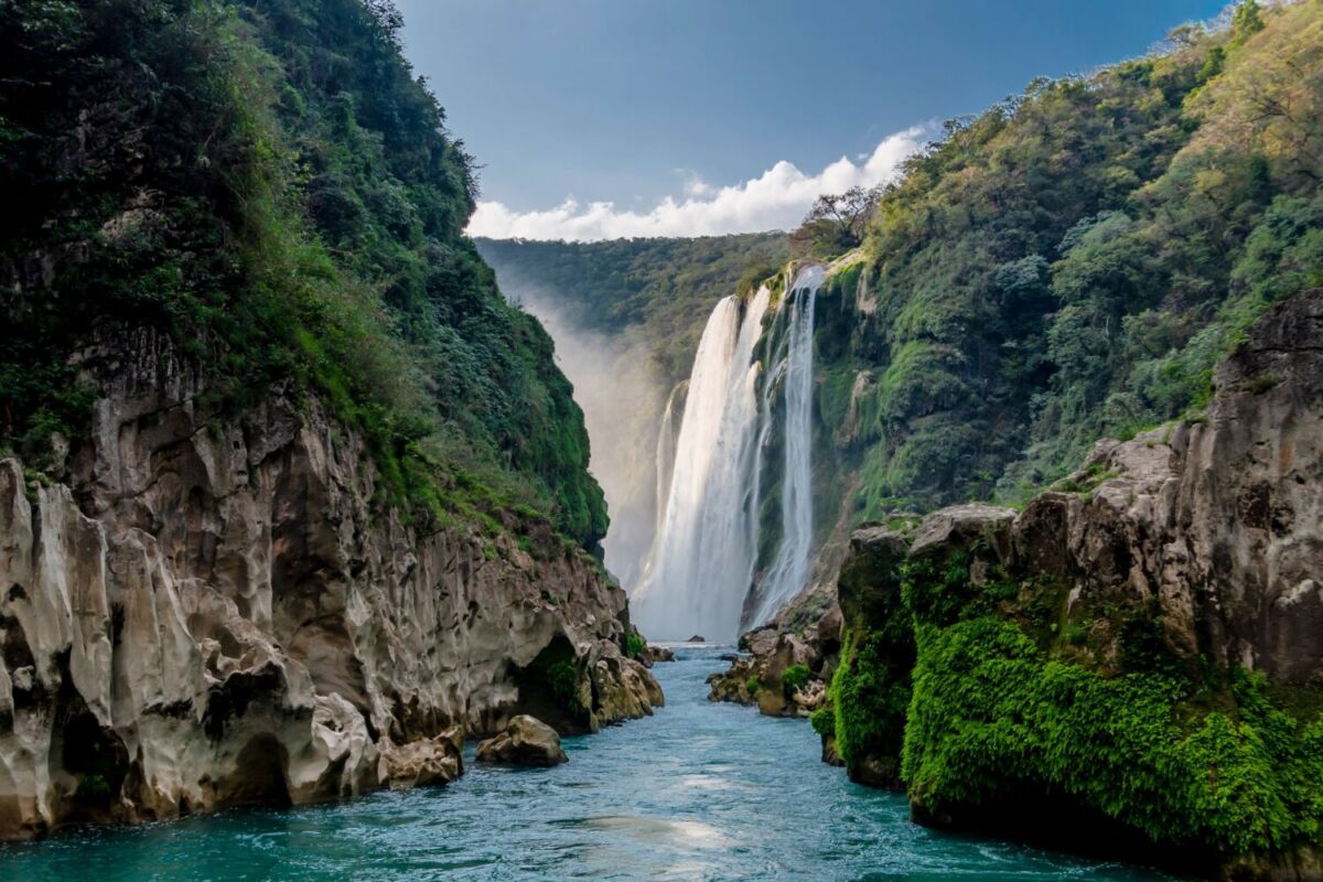 Cascada con montañas alrededor de día