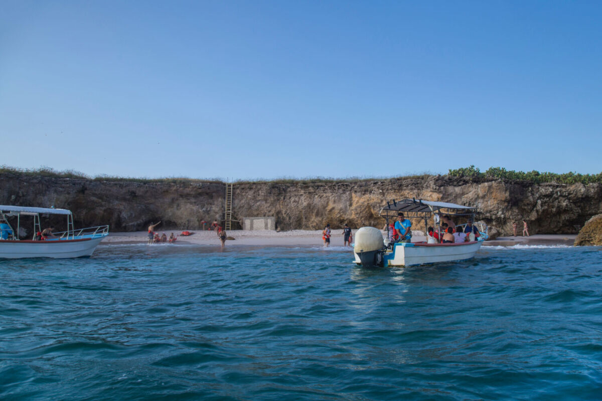 Pequeño bote con turistas camino a la Playa del Amor