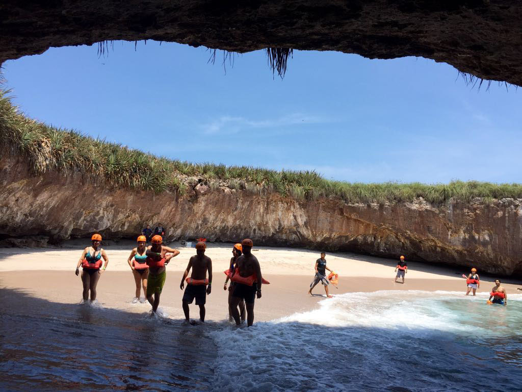 Un pequeño grupo de turistas dentro de la Playa del Amor en Nayarit