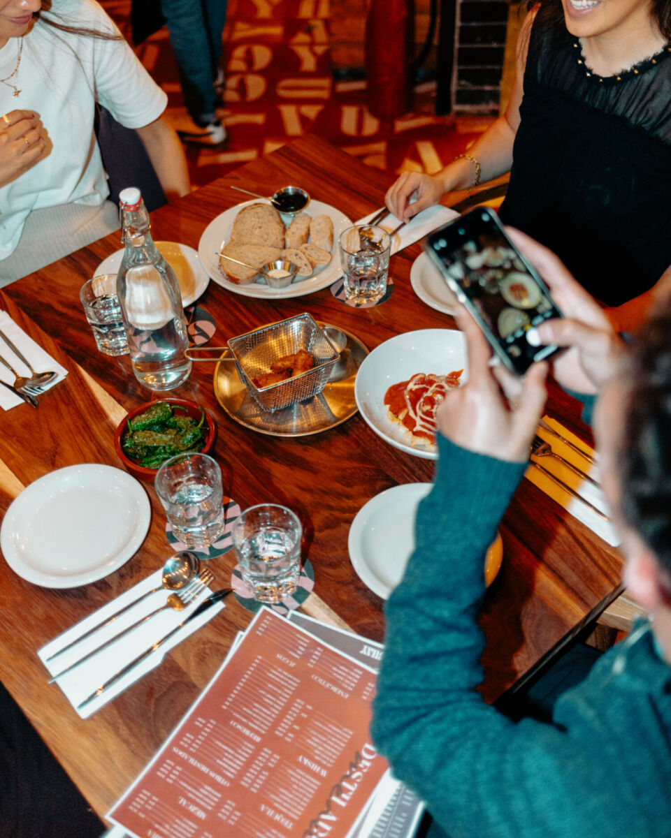 personas tomando fotos de tapas españolas en Guay en corredor juárez