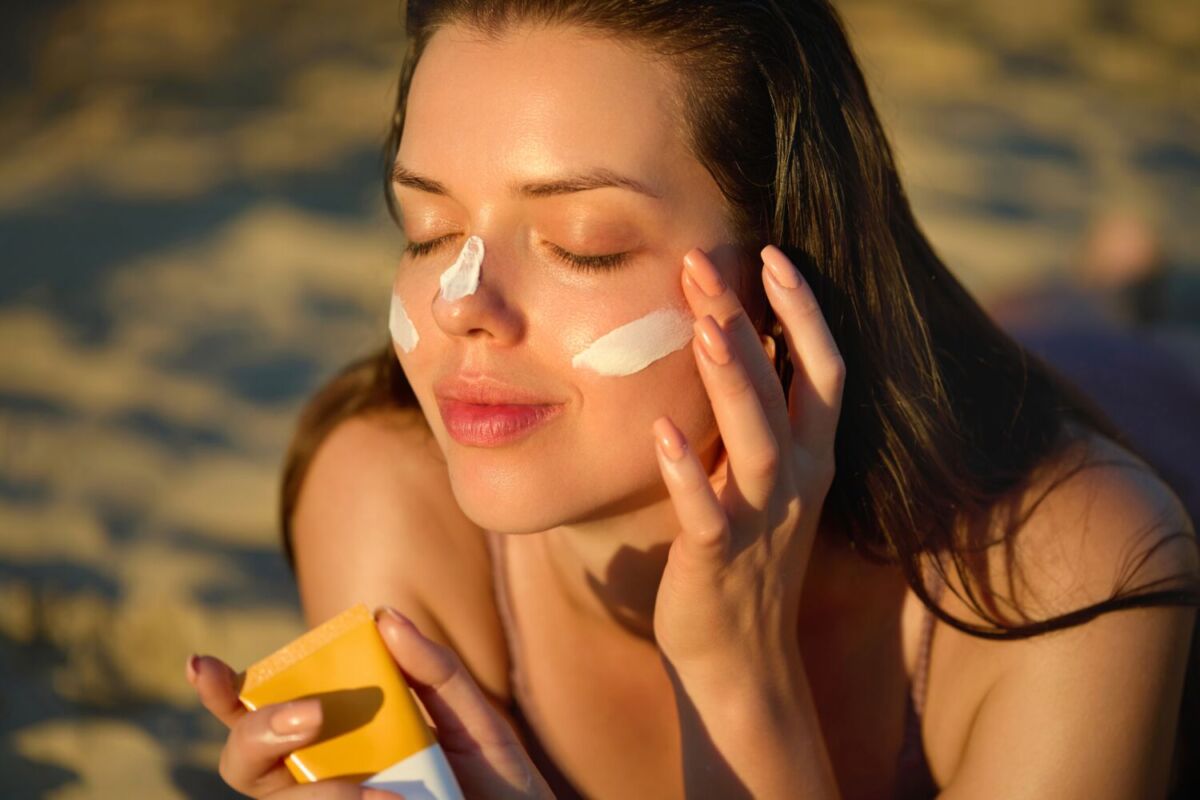 mujer aplicándose protector solar 