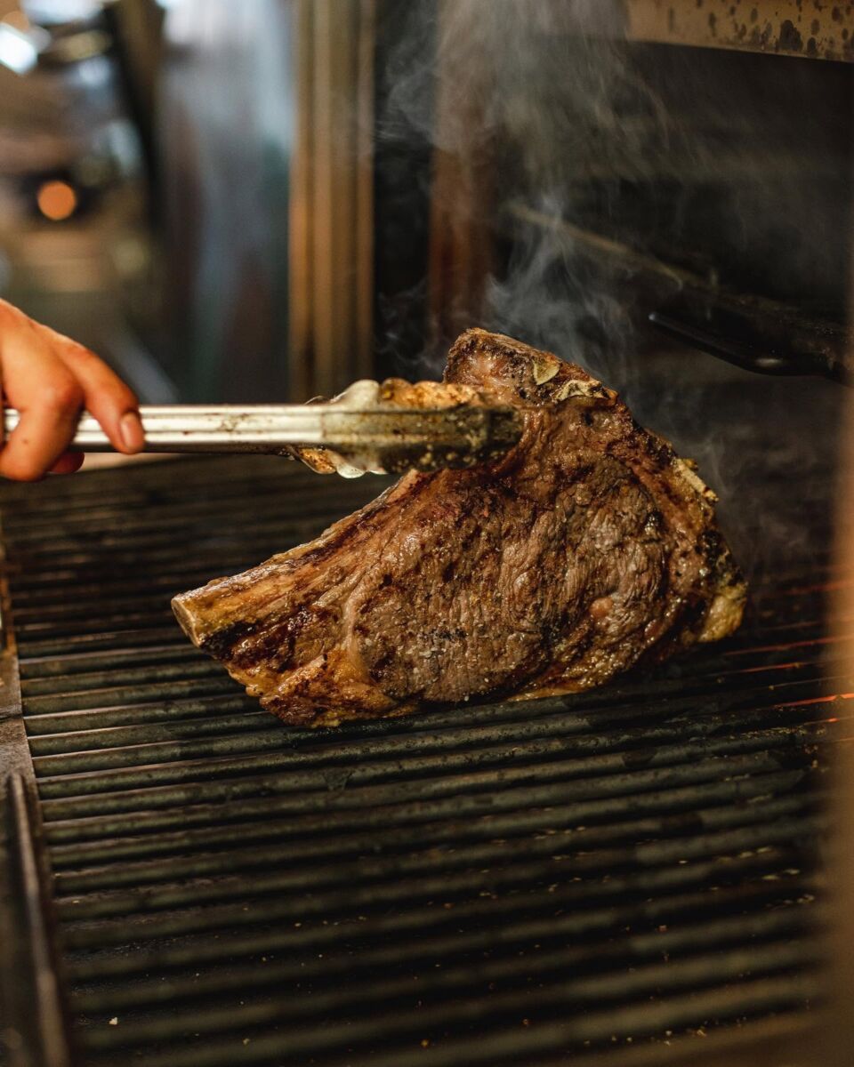 Corte de carne asándose en Dante Brasa y Fuego 