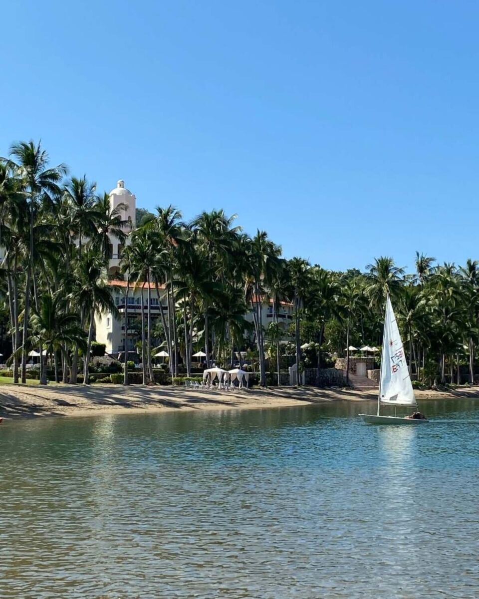 Velero navegando la Laguna de Navidad frente al Grand Isla Navidad Resort rodeado de palmeras de coco