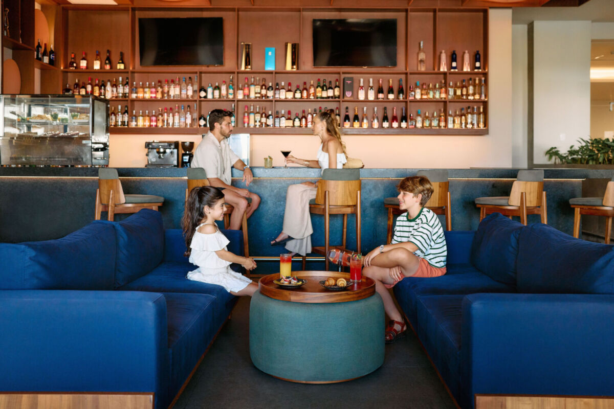 Una familia disfrutando un aperitivo en el lobby del hotel Hilton Cancun Mar Caribe All-Inclusive Resort 