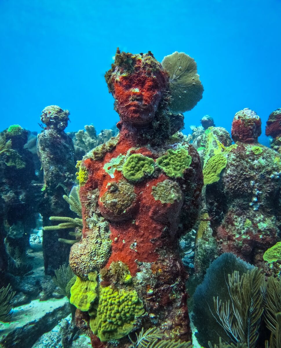 esculturas de mujeres debajo del agua en el mar