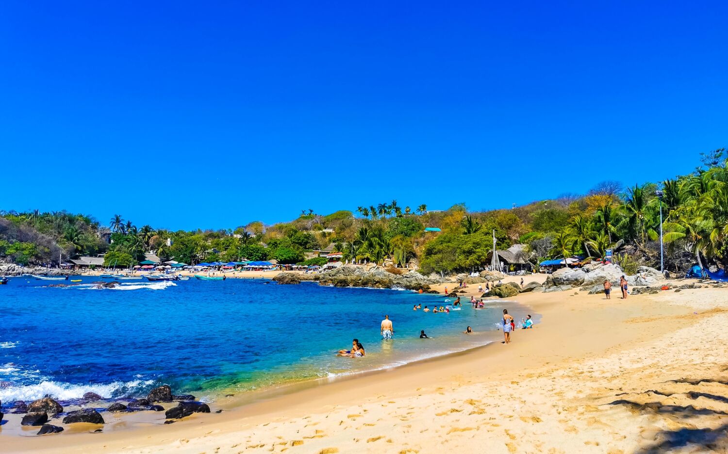La playa oaxaqueña protegida por una bahía: tiene aguas tranquilas poco profundas y palapas para comer mariscos La playa oaxaqueña protegida por una bahía: tiene aguas tranquilas poco profundas y palapas para comer mariscos