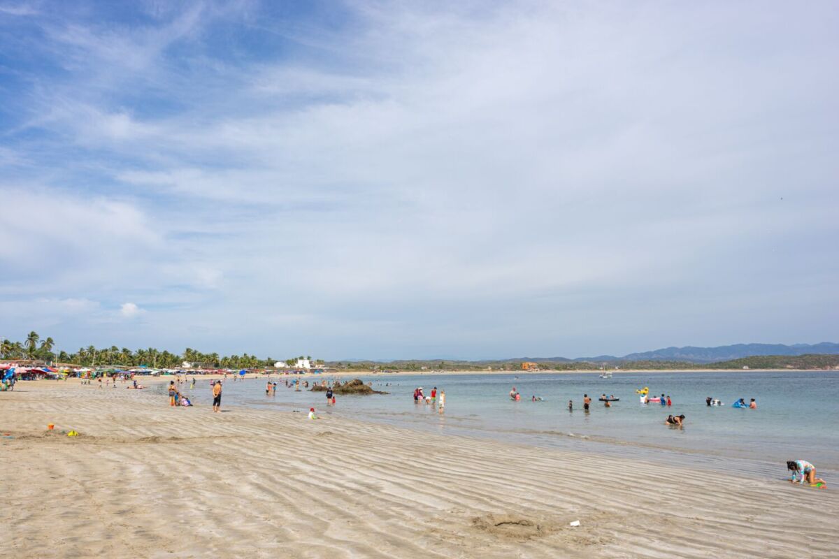 personas nadando en una playa de oleaje tranquilo