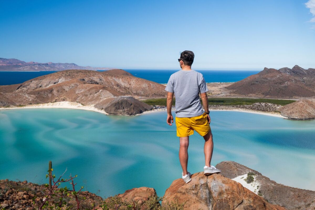 Un hombre viendo playa balandra desde lo alto