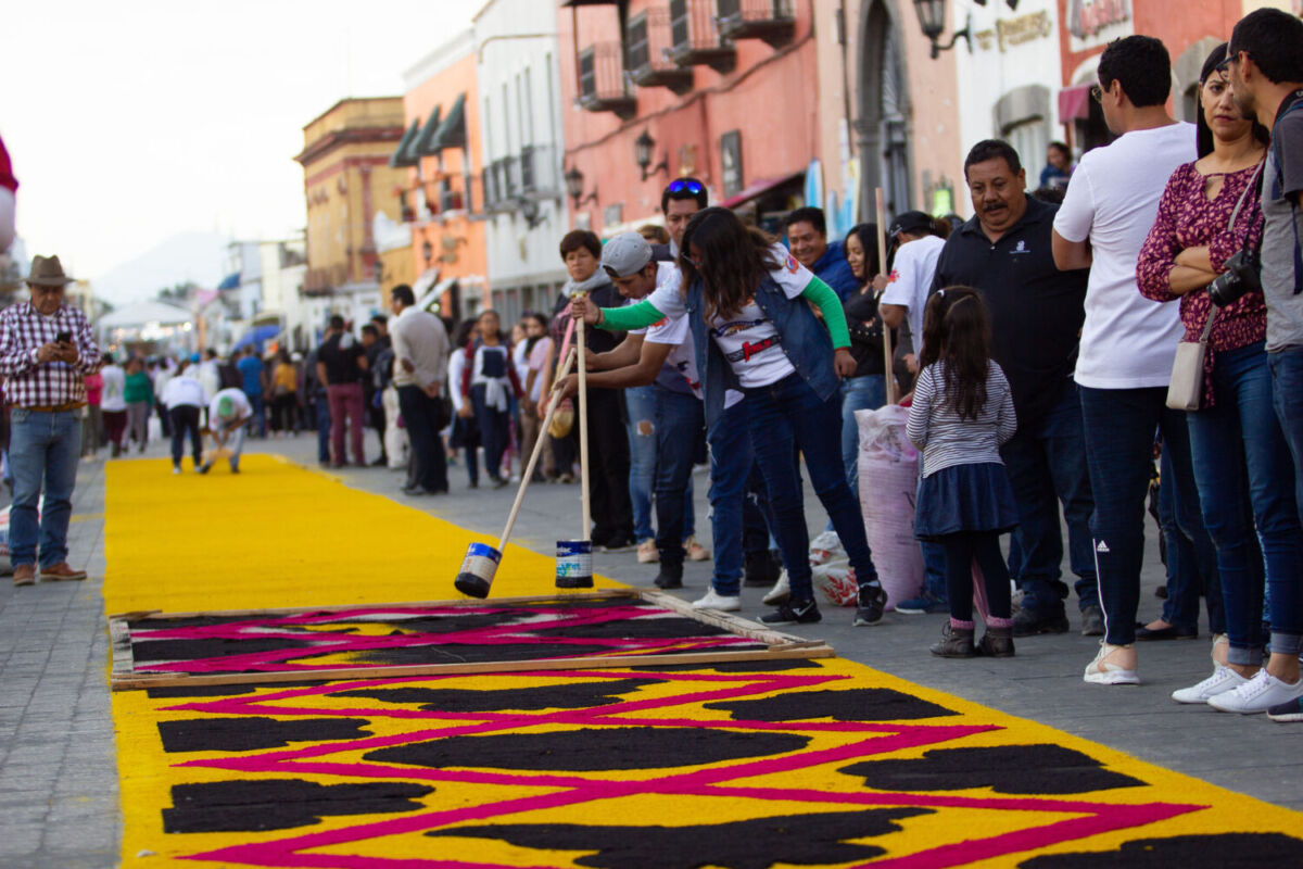 persona elaborando un tapete de aserrín 