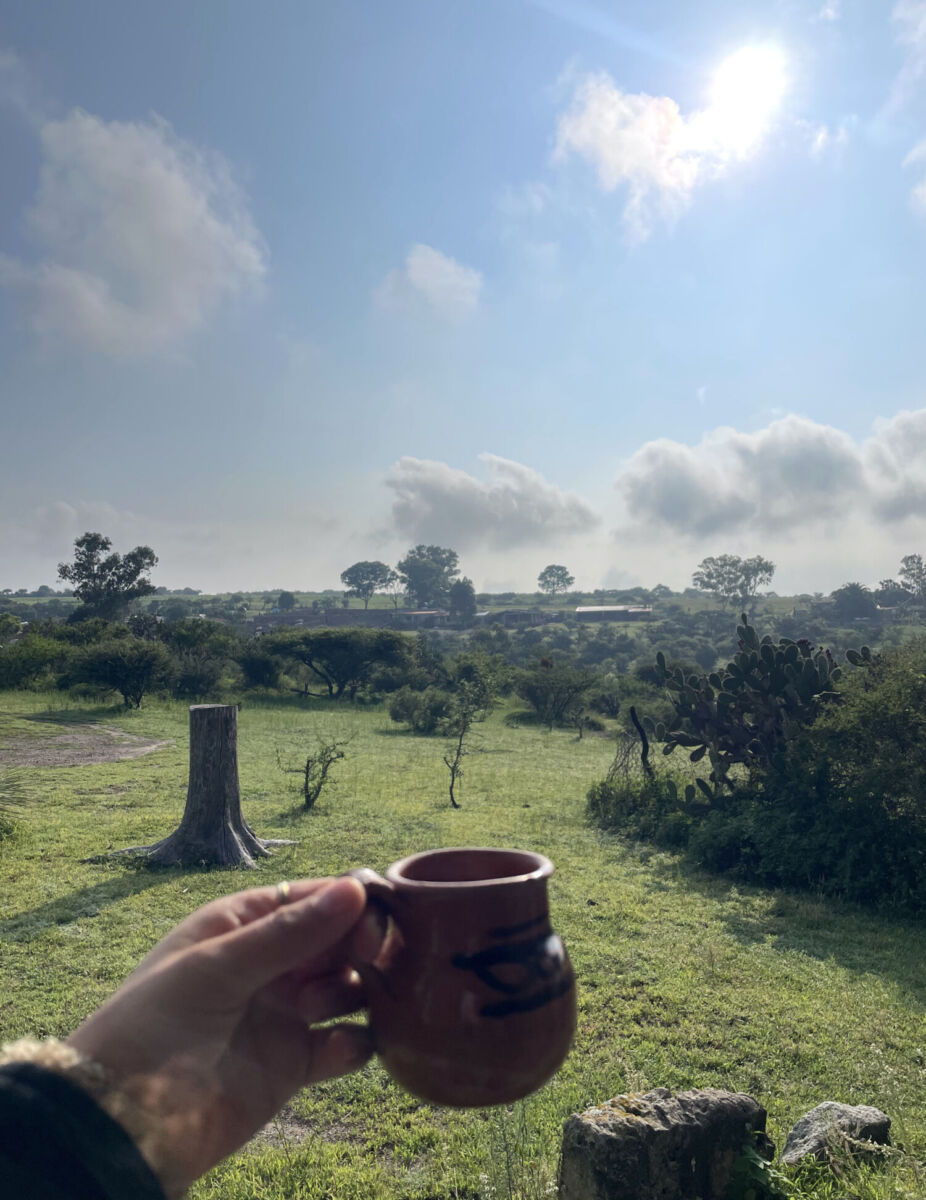 Taza de café de Olla y al fondo el Rancho Xotolar 