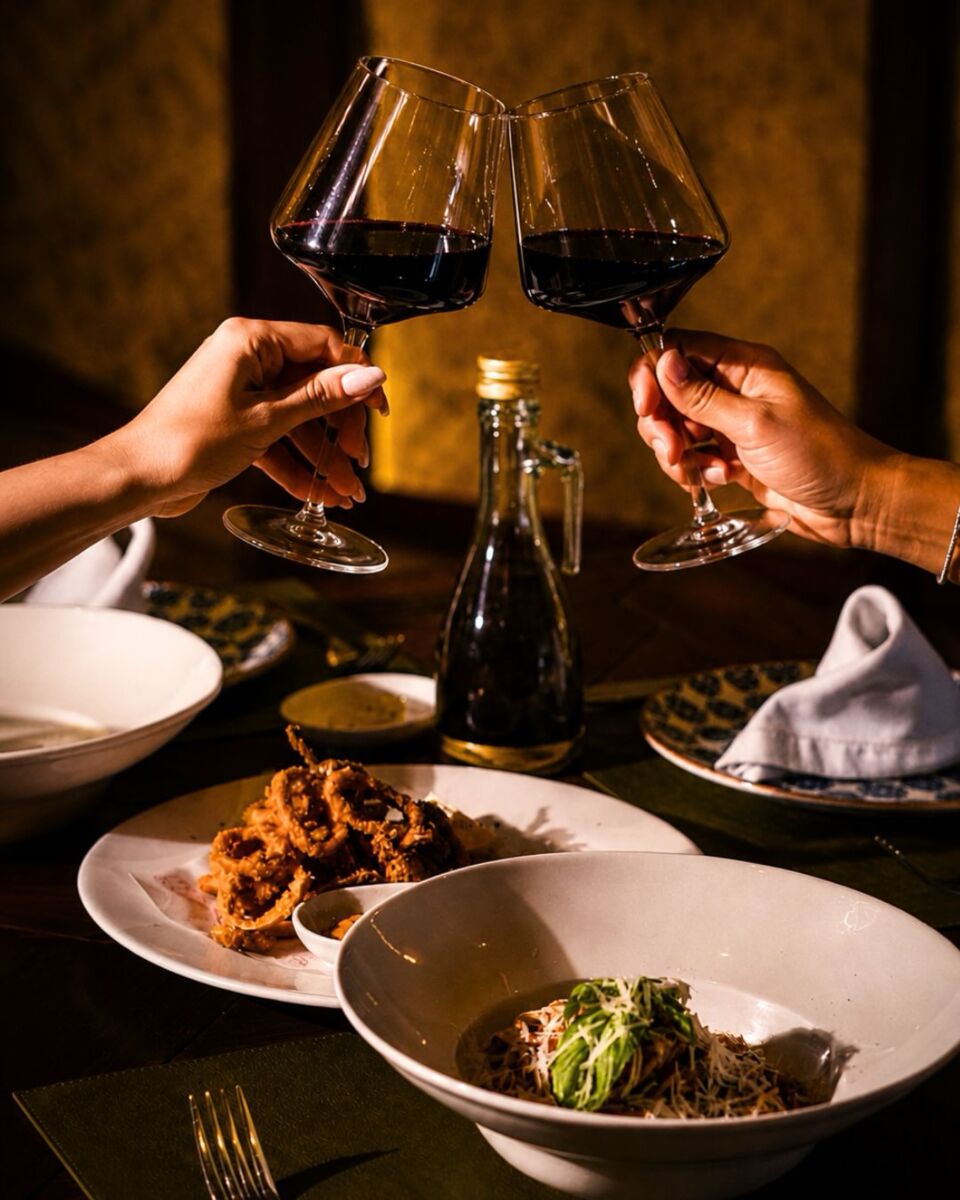 personas chocando copas de vino en restaurante italiano