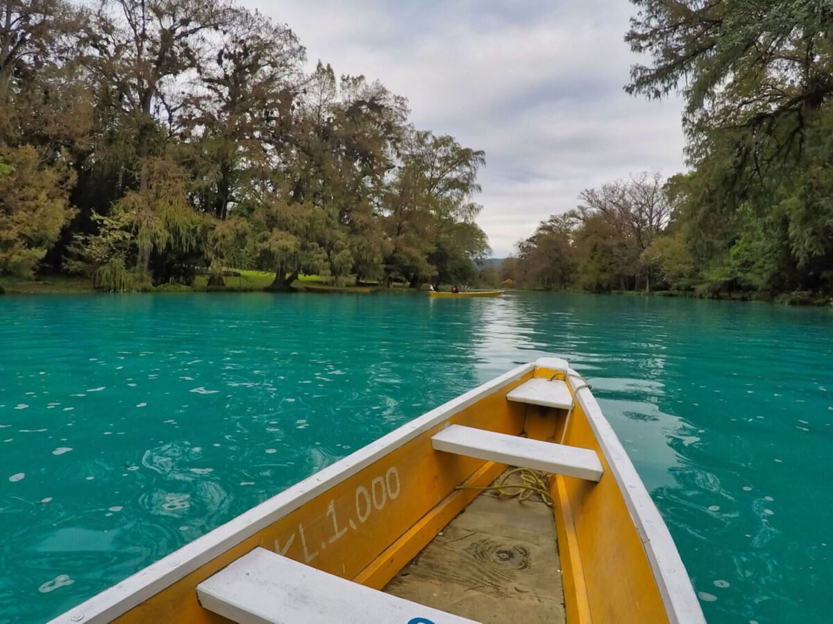 panga navegando en un río turquesa