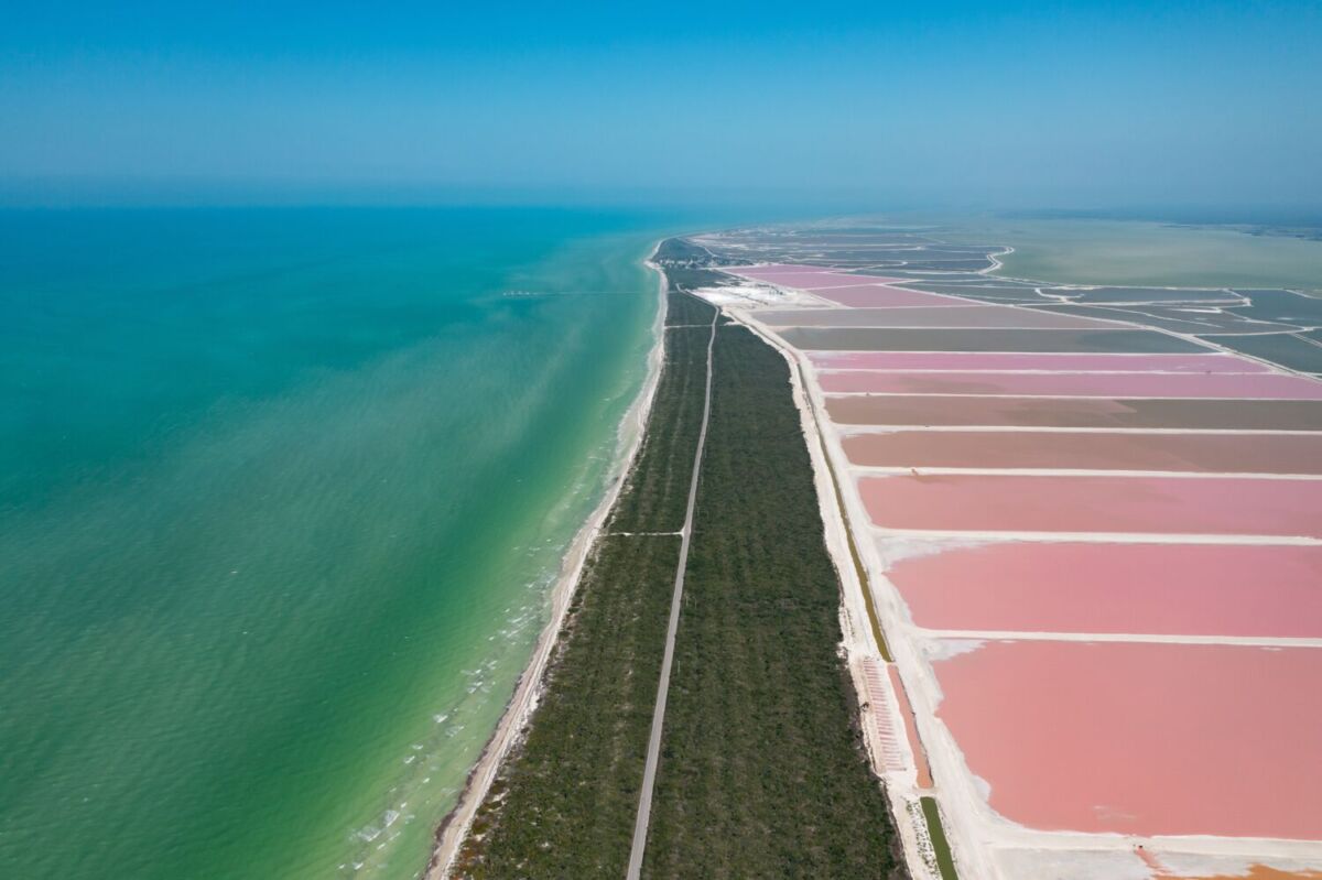 Vista aérea de las salineras rosas de Las Coloradas junto a la costa turquesa de la Reserva Ría Lagartos