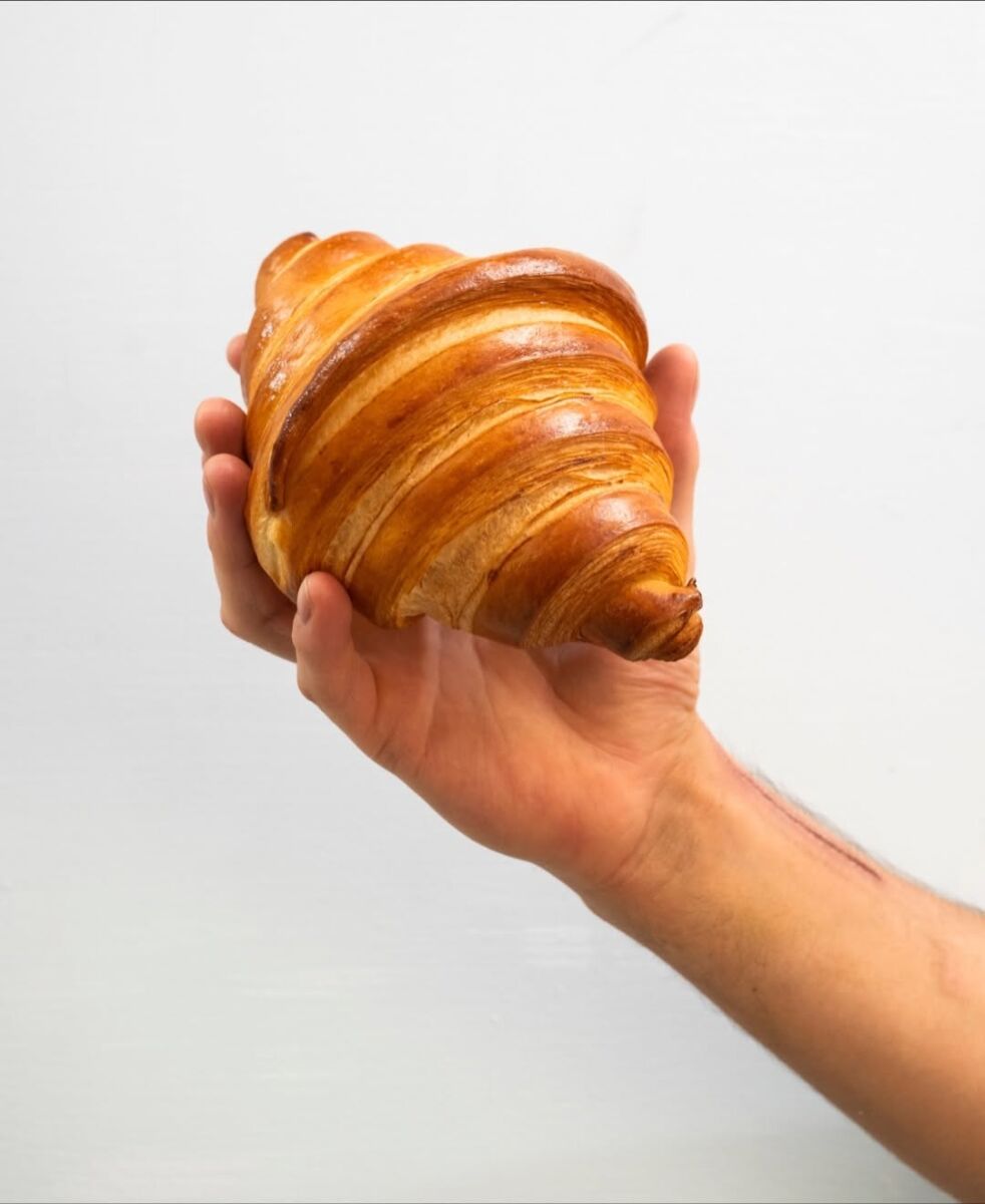 mano sosteniendo un croissant