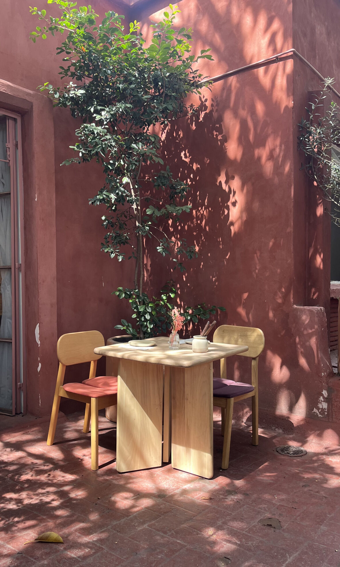 mesa con dos sillas en una terraza con sol