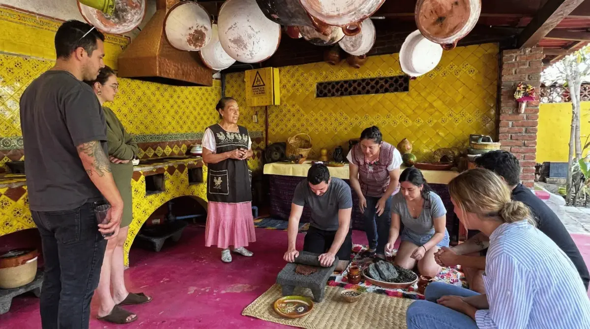turistas aprendiendo a usar metate
