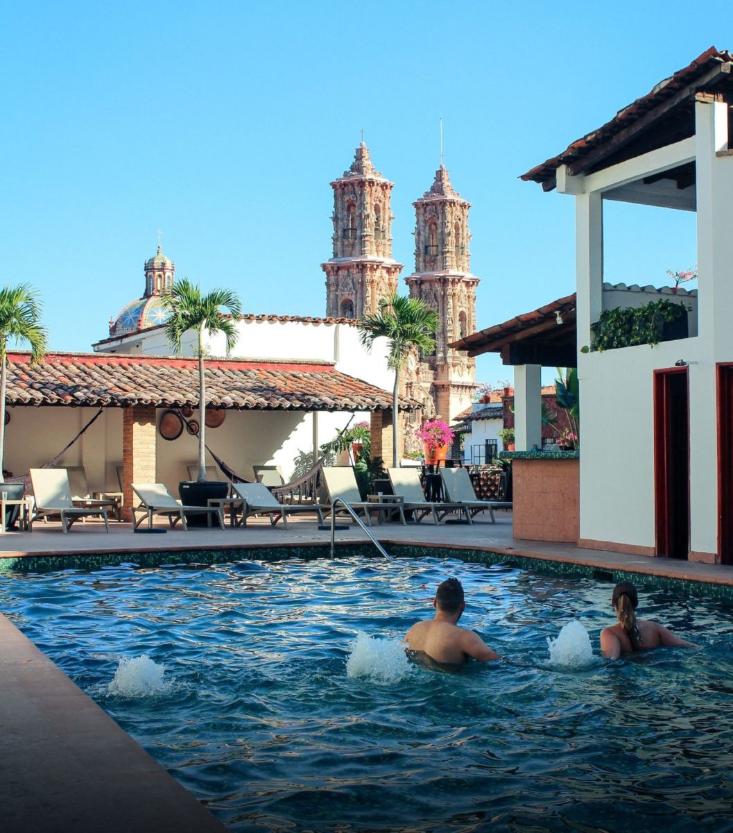 Pareja disfrutando de la alberca en un hotel de Taxco, Guerrero 
