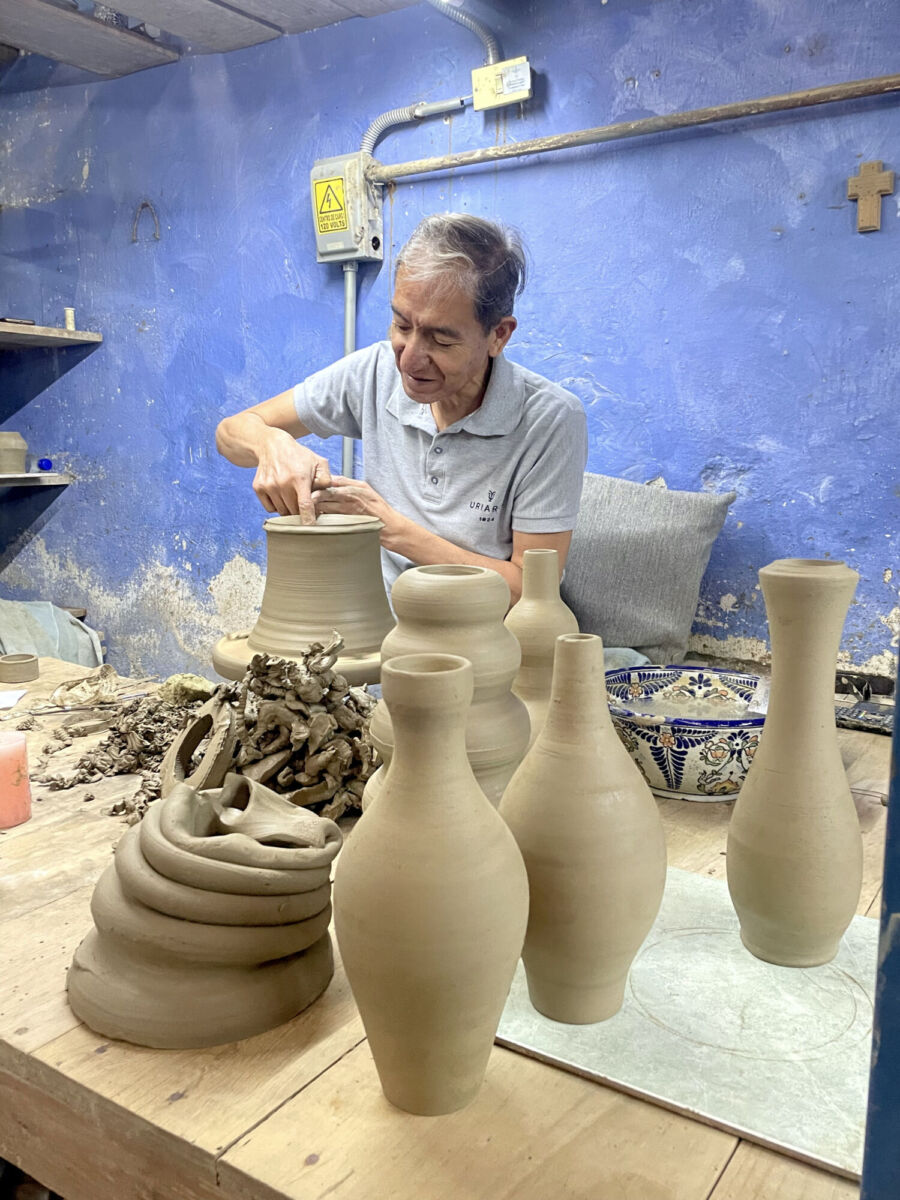Artesano moldeando una pieza de talavera en Puebla 