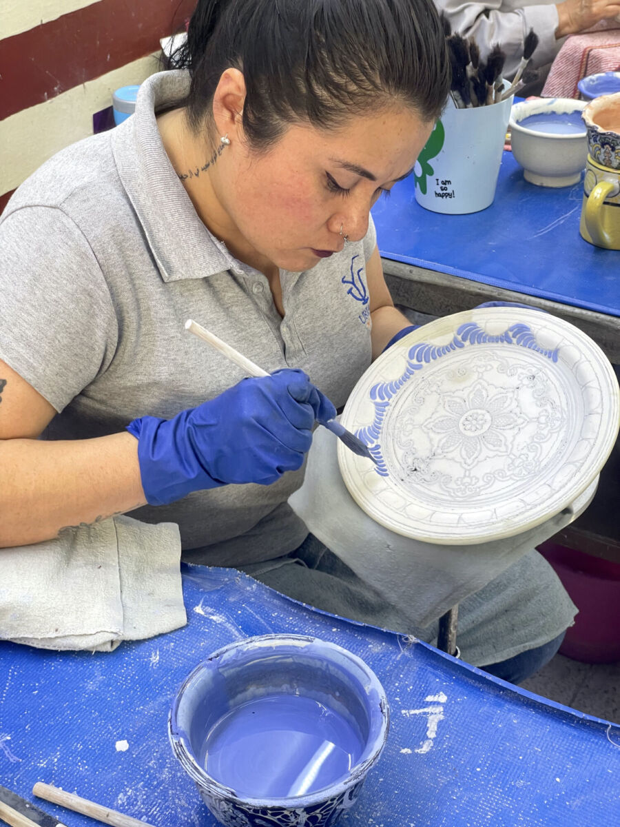 Artesana pintando una pieza de talavera 