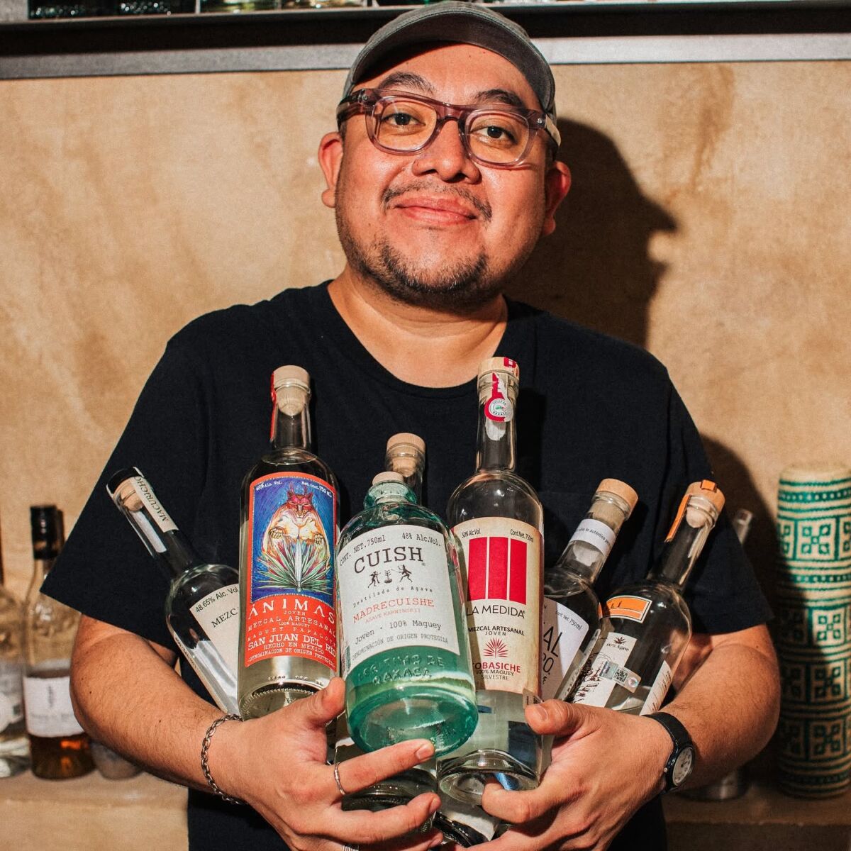 persona con botellas de mezcal artesanal