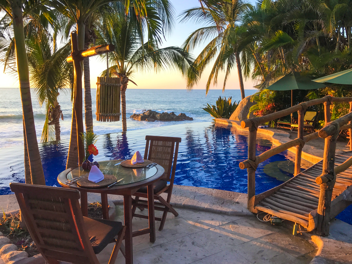 mesa de restaurante a un costado de una piscina al aire libre