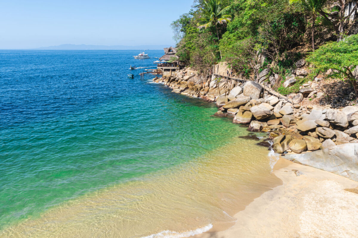 playa pequeña con agua cristalina y suave oleaje 