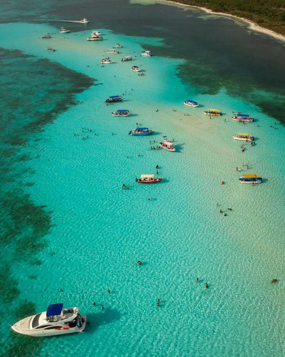 lanchas y barcos en una playa turquesa