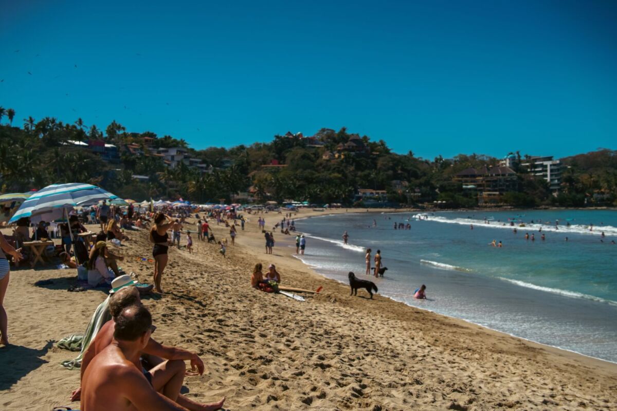 personas nadando y tomando el sol en la Playa de Sayulita