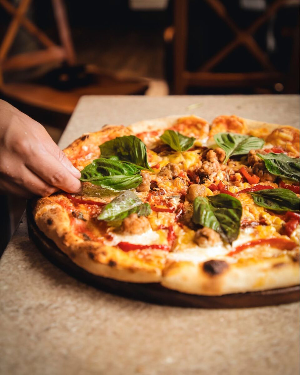persona tomando una rebanada de pizza