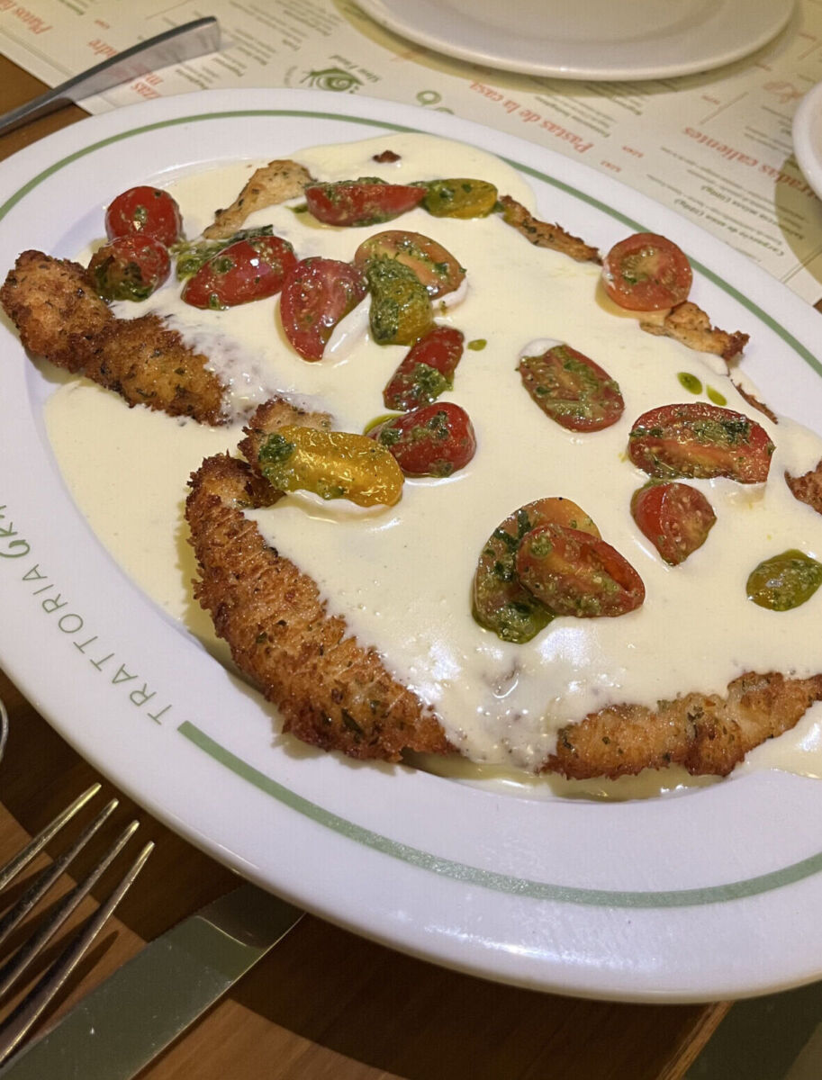 milanesa de pollo bañada en queso con jitomates