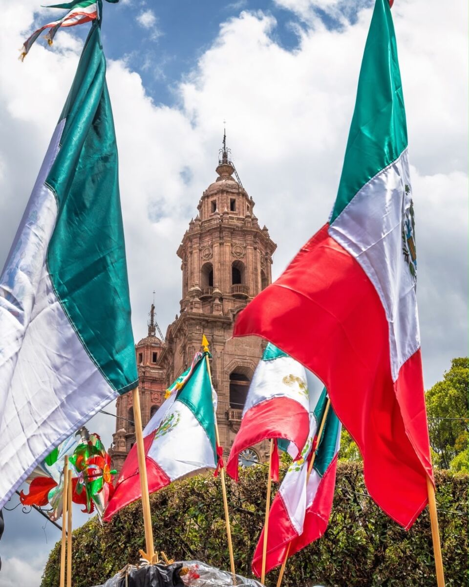 catedral en el fondo con banderas mexicanas