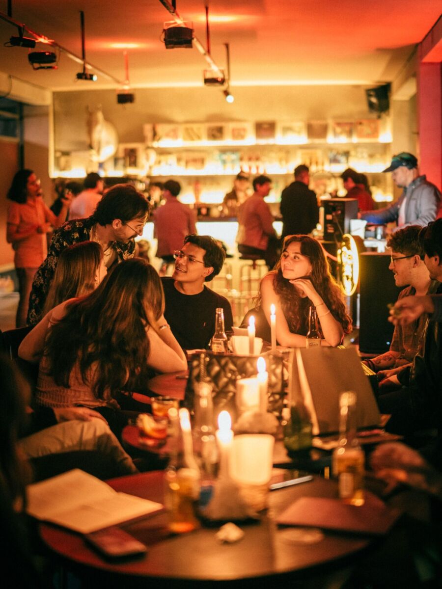 mesa de amigos en un bar con velas y luz cálida