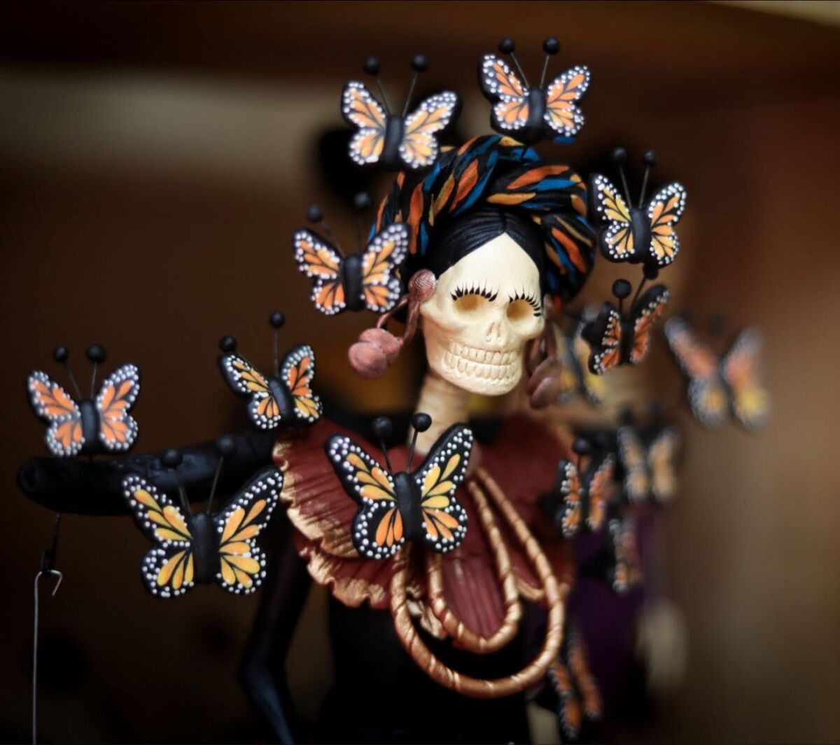 Catrina de barro con adornos de mariposas en Capula, Michoacán