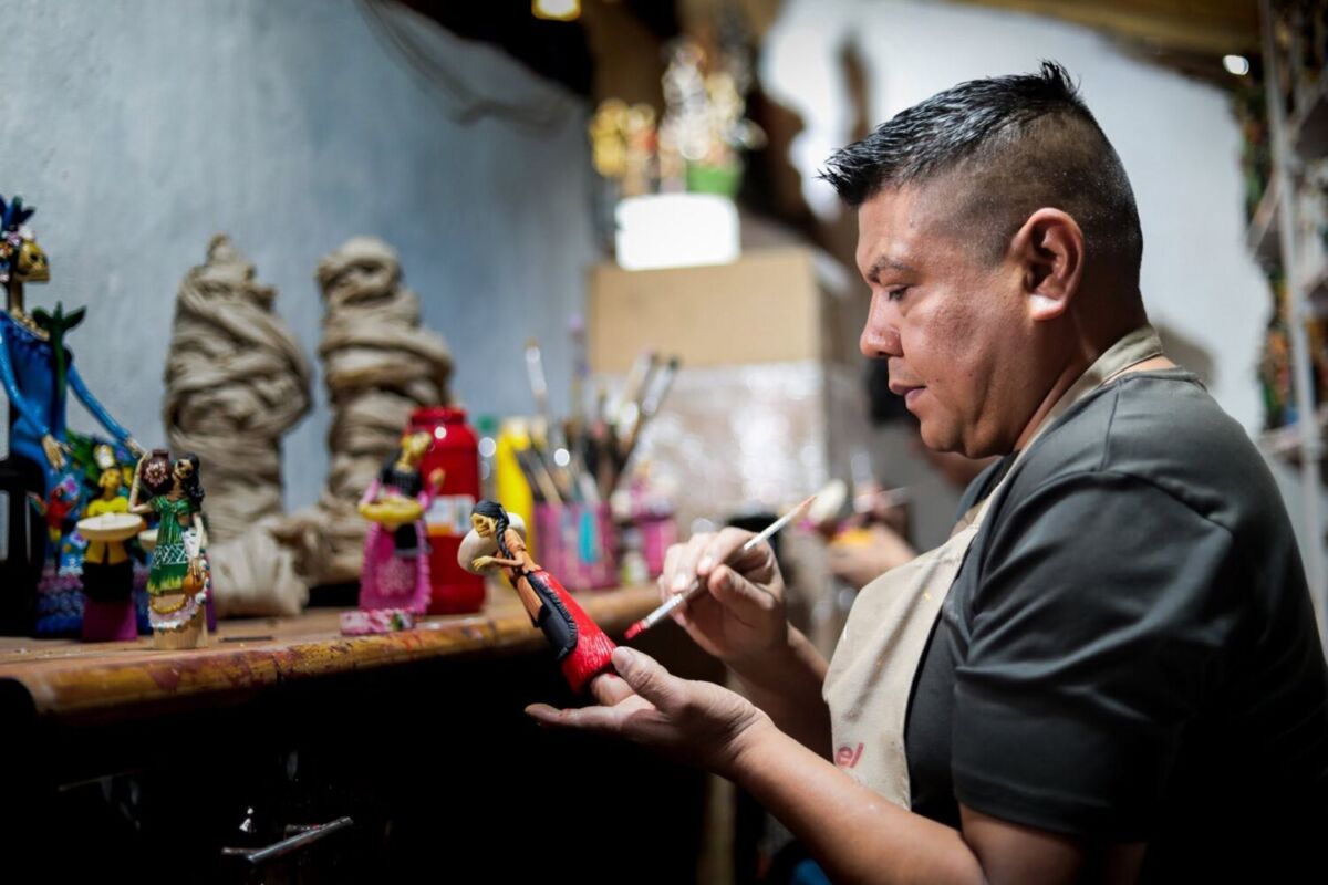 Artesano de Capula, Michoacán pintando una catrina