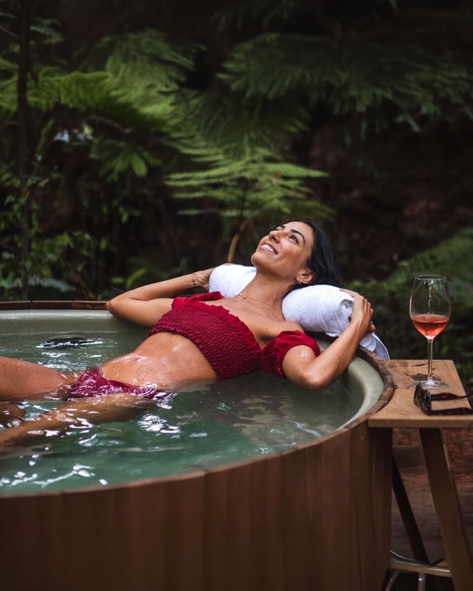 Una mujer disfrutando del jacuzzi en el bosque
