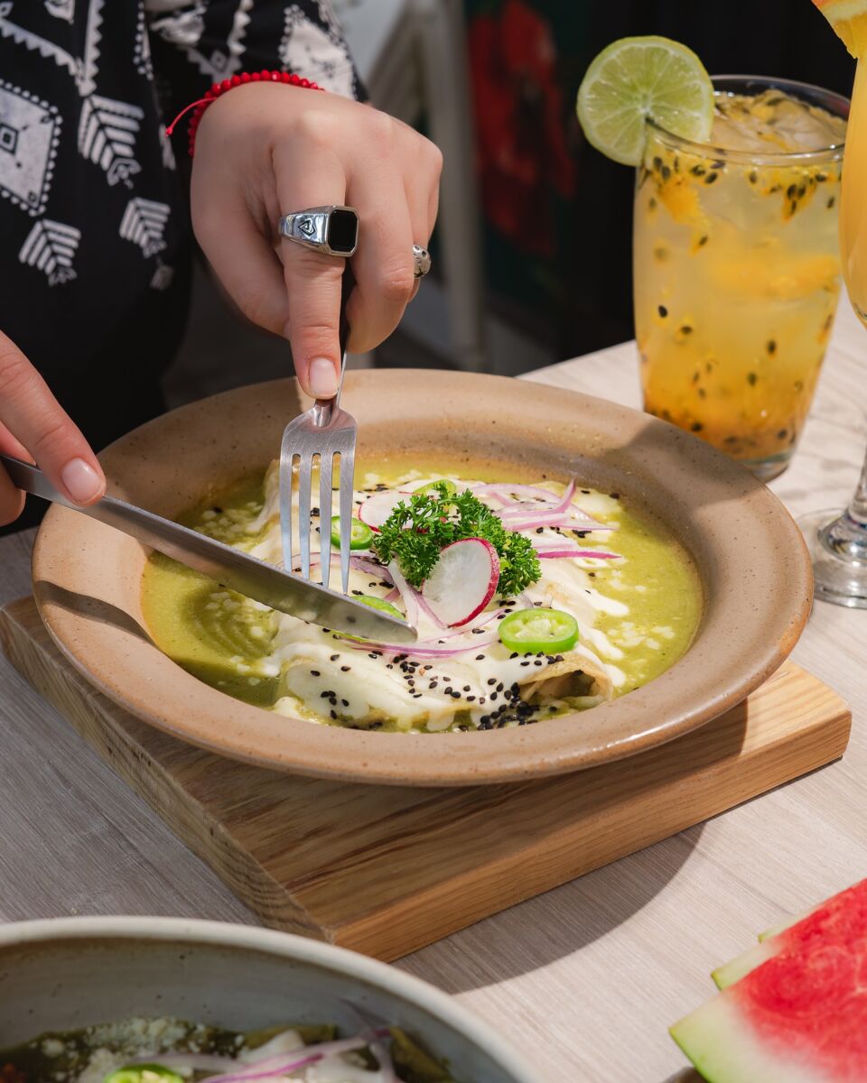 persona comiendo enchiladas suizas 