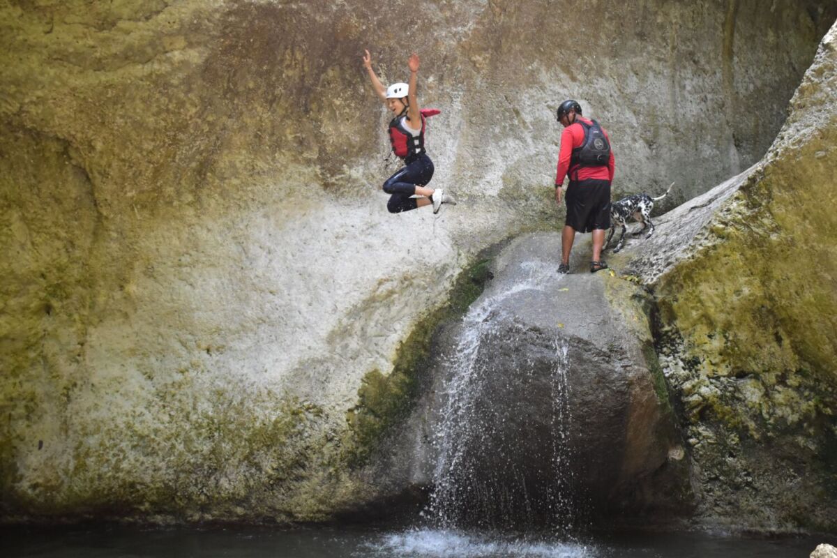 mujer saltando en una cascada