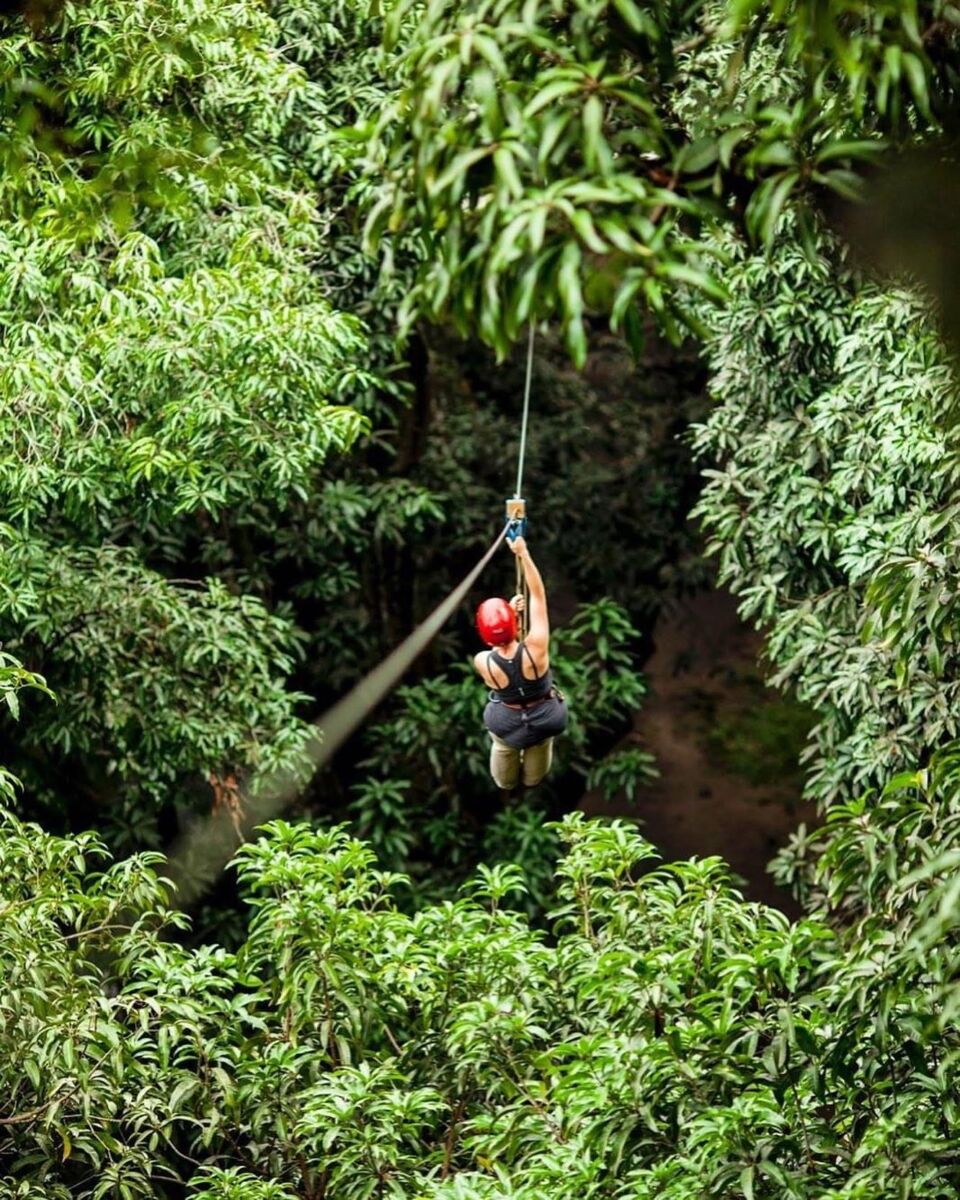 mujer en una tirolesa en la selva