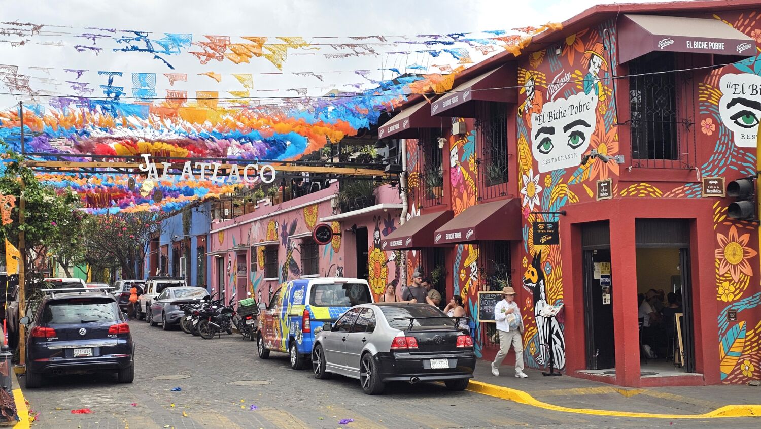 El barrio mexicano con casitas de colores llenas de murales y calles adornadas con papel picado El barrio mexicano con casitas de colores llenas de murales y calles adornadas con papel picado