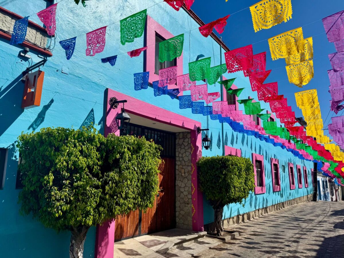 calle decorada con papel picado y casas coloridas en Jalatlaco, Oaxaca
