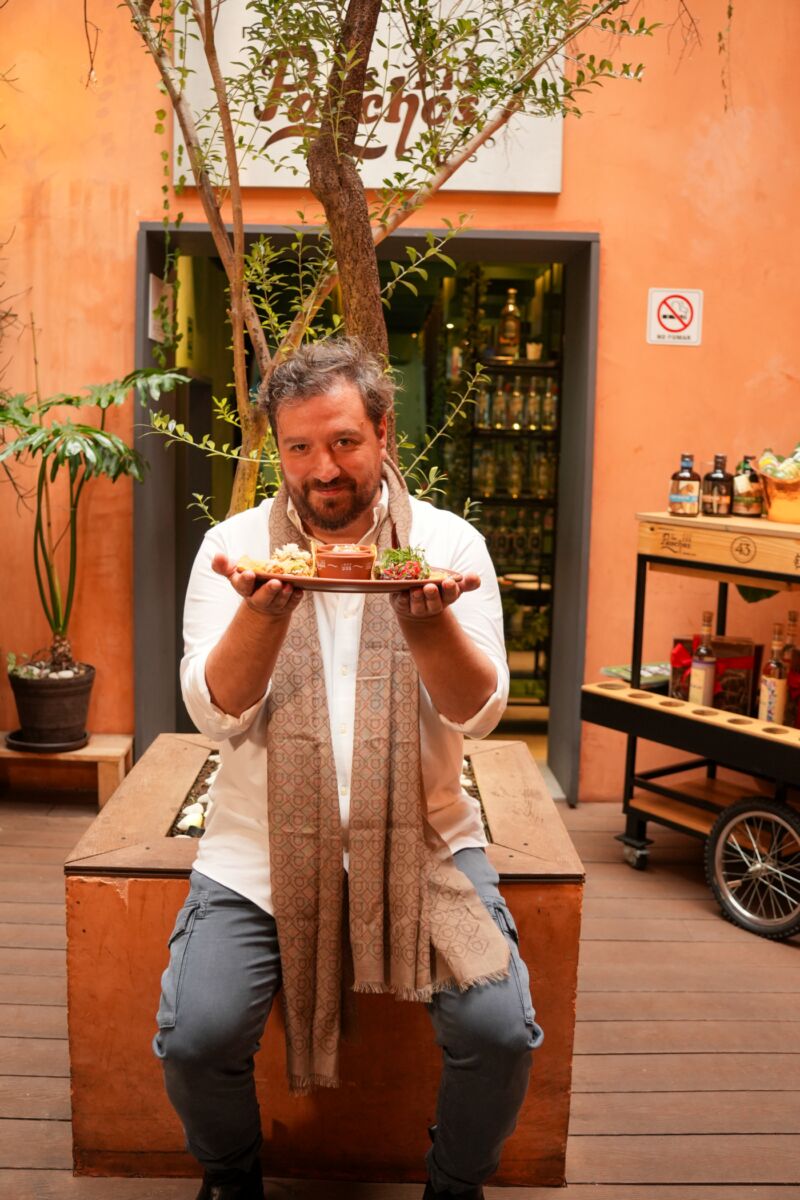 chef César de la Parra sosteniendo unos tacos de carnitas 