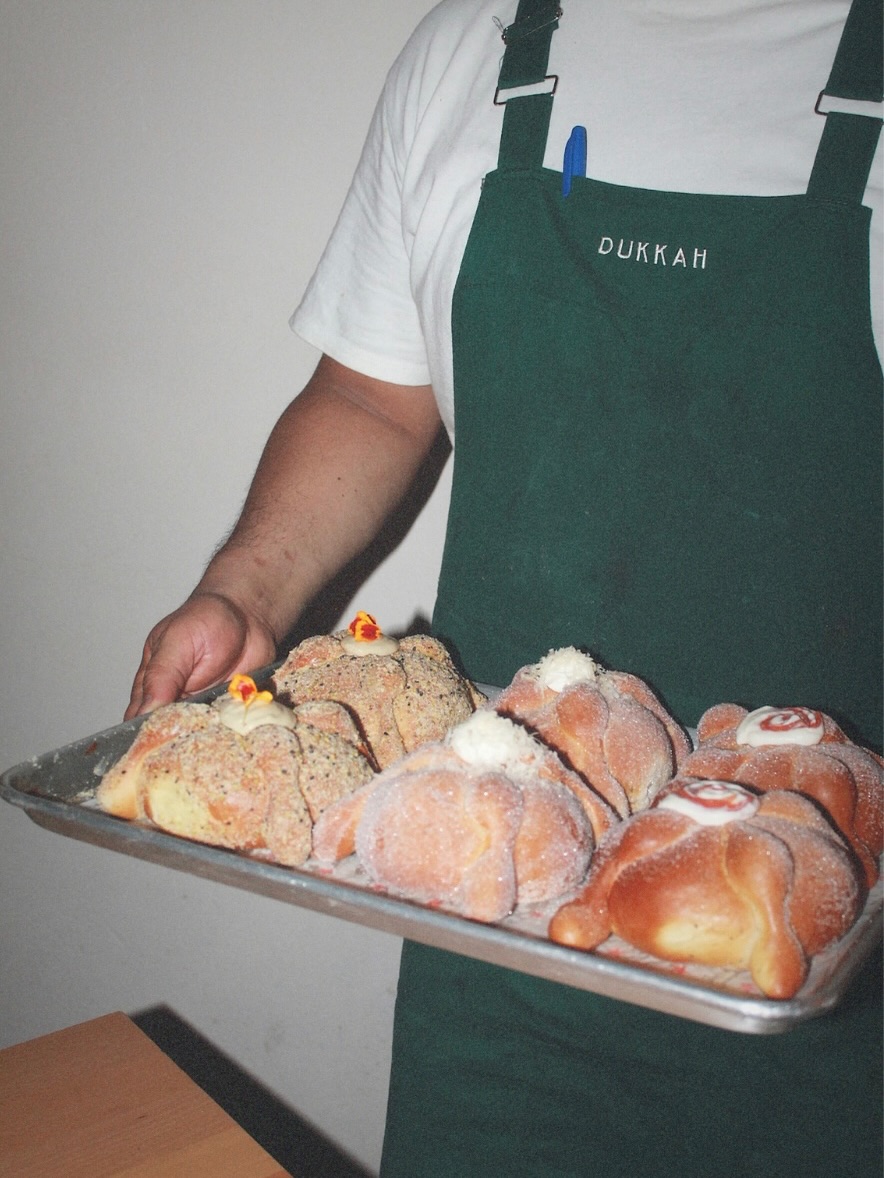 chef sosteniendo una bandeja con pan de muerto