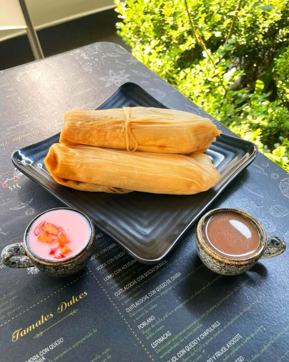 tamales en un plato y tazas de atoles 