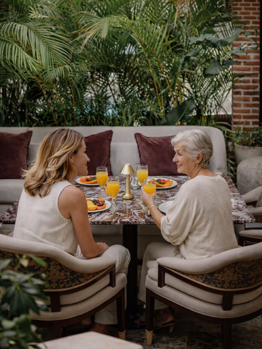 abuela y nieta desayunando fruta en un restaurante elegante